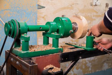 Marangoz torna tezgahına odun koymaya hazırlanıyor.