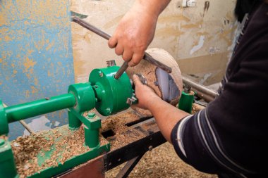 Marangoz torna tezgahına odun koymaya hazırlanıyor.