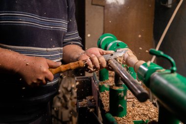 Marangozun torna tezgahına odun çevirdiği yakın plan. Torna tezgahına keski şamdanı oyan kişi