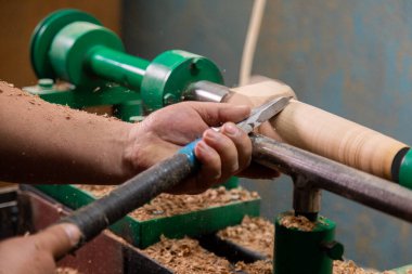 Marangozun torna tezgahına odun çevirdiği yakın plan. Torna tezgahına keski şamdanı oyan kişi