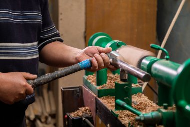 Marangozun torna tezgahına odun çevirdiği yakın plan. Torna tezgahına keski şamdanı oyan kişi