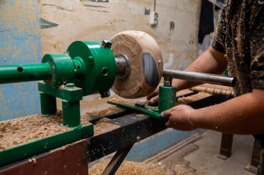 Marangoz torna tezgahına odun koymaya hazırlanıyor.