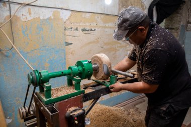 Marangoz torna tezgahına odun koymaya hazırlanıyor.