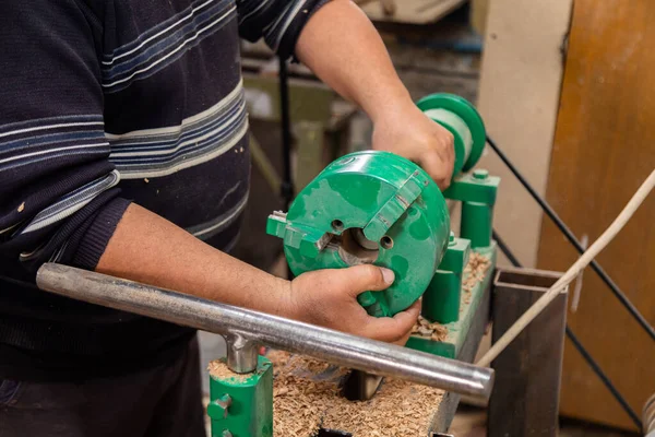 Marangoz torna tezgahına odun koymaya hazırlanıyor.