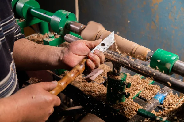 Marangozun torna tezgahına odun çevirdiği yakın plan. Torna tezgahına keski şamdanı oyan kişi