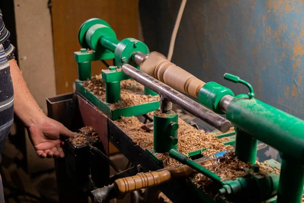 Marangoz torna tezgahına odun koymaya hazırlanıyor.