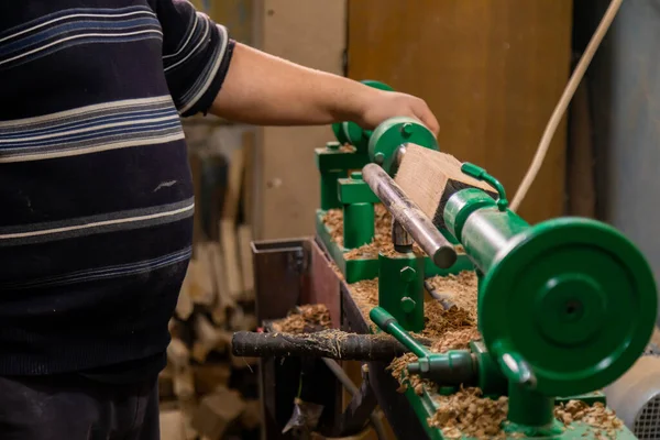 Marangoz torna tezgahına odun koymaya hazırlanıyor.