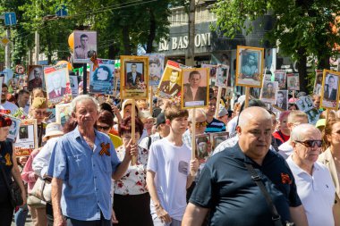 Bishkek, Kırgızistan - 9 Mayıs 2022: 9 Mayıs Zafer Günü ölümsüz alay. İnsanlar büyük vatanseverlik savaşına katılan akrabalarının afiş resimleriyle köşe yazıları yazıyorlar.
