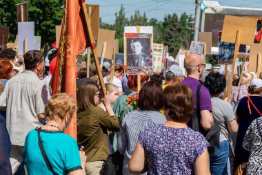 Bishkek, Kırgızistan - 9 Mayıs 2022: 9 Mayıs Zafer Günü ölümsüz alay. İnsanlar büyük vatanseverlik savaşına katılan akrabalarının afiş resimleriyle köşe yazıları yazıyorlar.