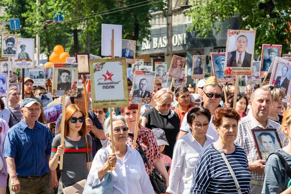 Bishkek, Kırgızistan - 9 Mayıs 2022: 9 Mayıs Zafer Günü ölümsüz alay. İnsanlar büyük vatanseverlik savaşına katılan akrabalarının afiş resimleriyle köşe yazıları yazıyorlar.