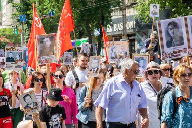 Bishkek, Kırgızistan - 9 Mayıs 2022: 9 Mayıs Zafer Günü ölümsüz alay. İnsanlar büyük vatanseverlik savaşına katılan akrabalarının afiş resimleriyle köşe yazıları yazıyorlar.