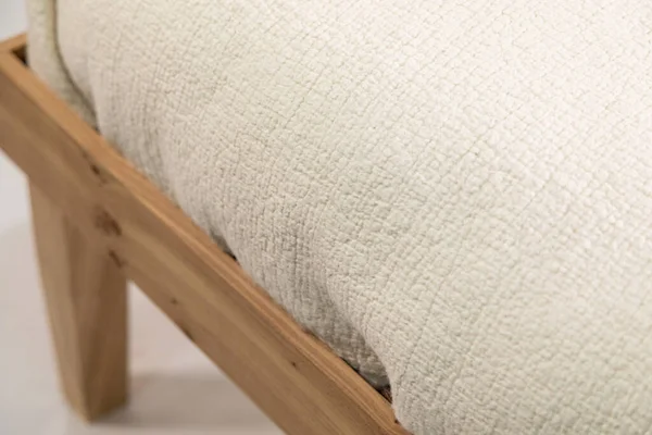 Beyaz arka planda izole edilmiş ahşap bir komodinin üzerinde el yapımı sütlü keçeli yastık.