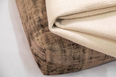 El yapımı tırmalanmış yastık ve beyaz arka planda beyaz keçeli battaniye.