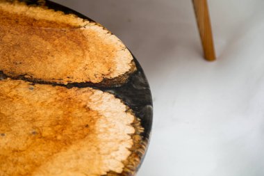 Beyaz arkaplanda epoksi reçine yuvarlak masa kenarının kapatılması