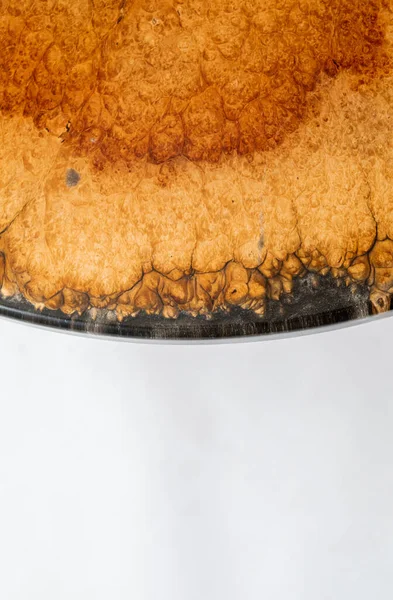 Closeup of epoxy resin round table edge on white background