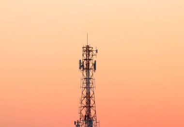 Telecommunication tower silhouette during sunset with pastel sky background. Concept of digital infrastructure, wireless communication, mobile network, and 5G technology