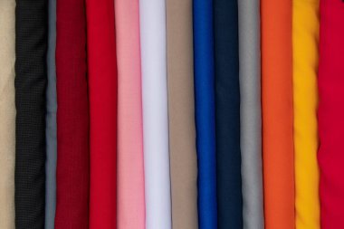 Colorful fabric rolls neatly arranged, displaying a wide variety of colors and textures for design projects