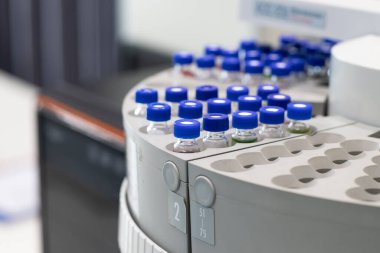High-precision laboratory vials with blue caps automatic sample carousel of gas chromatography, used for scientific research, chemical analysis, pharmaceutical testing, laboratory automation processes