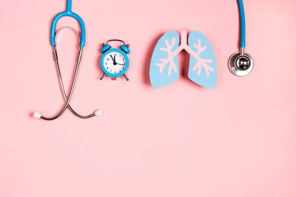 肺疾患の予防 肺のシンボルピンクの背景に聴診器と目覚まし時計 医療の概念 — ストック写真