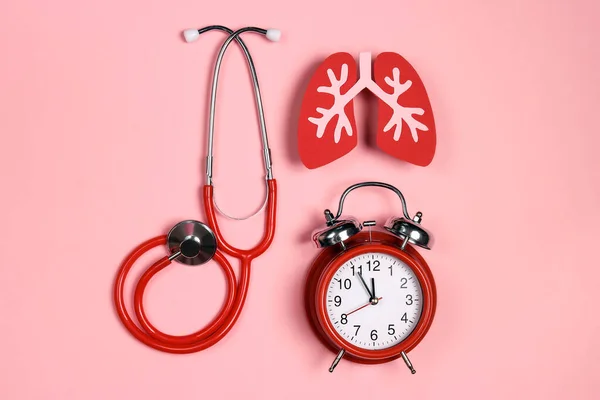肺疾患の予防 肺のシンボルピンクの背景に聴診器と目覚まし時計 医療の概念 — ストック写真