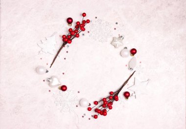 Beyaz süslemeler ve açık mermer arka planda kırmızı böğürtlenlerden yapılmış Noel çerçevesi. Boşluğu kopyala, üst görünüm, düz uzanma.