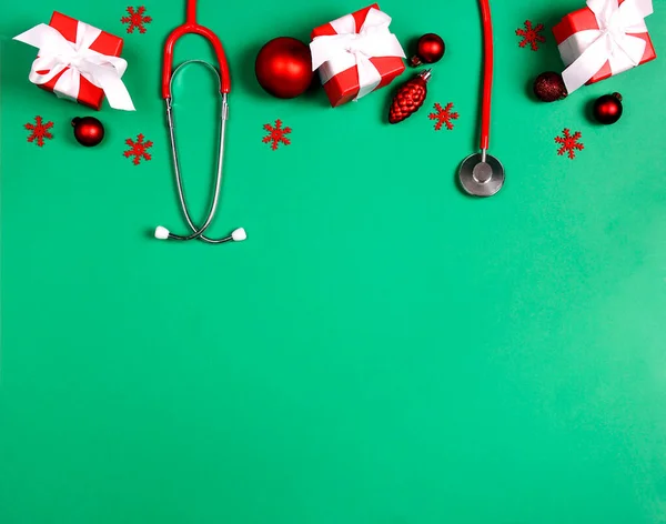 緑の背景にクリスマスの装飾と聴診器 医療業界でクリスマスを祝う テキストのコピースペース — ストック写真