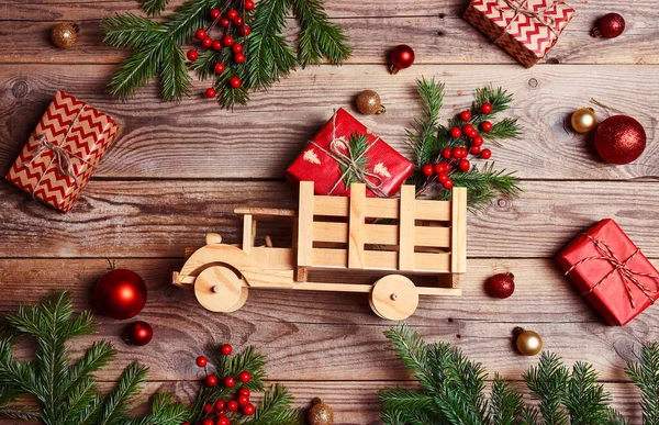 木制玩具卡车 装有礼品盒 冷杉树枝和木制背景的圣诞装饰 自上而下的组成 — 图库照片