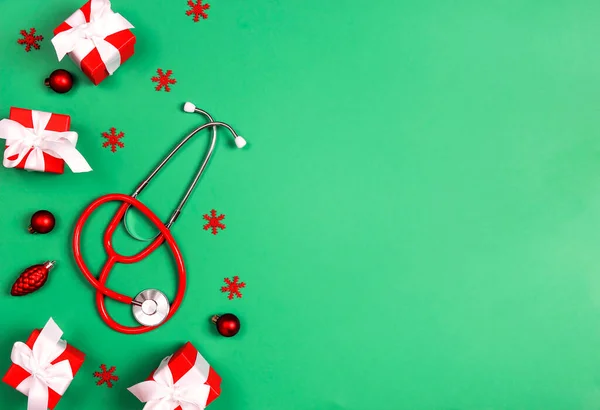 緑の背景にクリスマスの装飾と聴診器 医療の概念のためのクリスマスグリーティングカード テキストのコピースペース — ストック写真