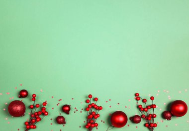 Kırmızı süslemeler ve yeşil arka planda böğürtlenler. Noel, kış, fotokopi alanı ile yeni yıl kavramı.
