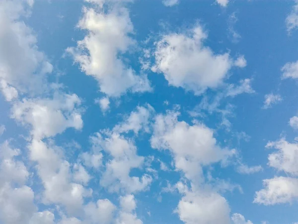 Güneşli bir günde bulutlu mavi gökyüzü. Güneş ve güneş ışınları mavi gökyüzüne ve bulutlara karşı. Mavi gökyüzündeki puslu gökyüzünde güneş ışığı.