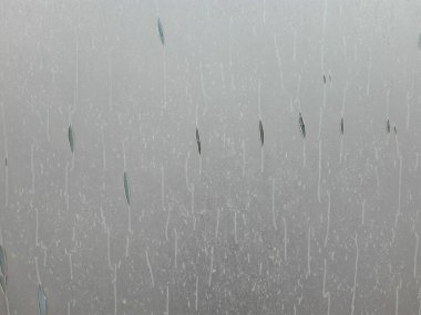 Silver plastic foil background. Bright and scratched surface. Glass covered with plastic foil. Scratched plastic foil texture.