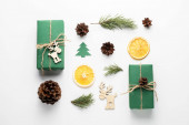 Vánoční kompozice. Dárky, jedlové větve, kornouty, sušená pomeranč na bílém pozadí. Koncepty Vánoc, zimy, Nového roku. Horní pohled