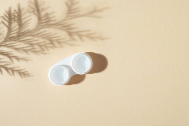 Bej arkaplandaki bir konteynırdaki gözler için kontak lensleri, üst görünüm