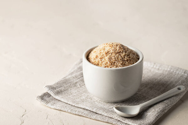 Куча оболочек псиллия в миске на столе. Диетическая добавка, супереда. Копирование пространства