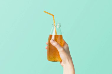 Kadın eli, renkli bir duvarın arka planında chia tohumları olan tutkulu meyve suyu tutuyor..