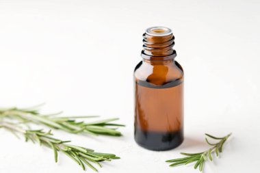 Hafif arka planda cam şişelerde biberiye yağı. Aromaterapi.
