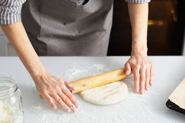 Mutfakta bir kadın para dağıtıyor. Maya hamur tatlısı..