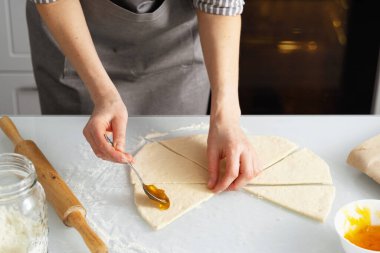 Bir kadın mutfakta reçelli simit pişiriyor. Kendi ellerinle tatlı hamur işi