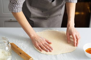 Bir kadın mutfakta reçelli simit pişiriyor. Kendi ellerinle tatlı hamur işi