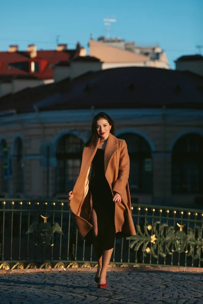 Mantolu kız gün doğumunda sokakta