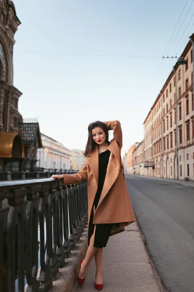 Дівчина в пальто на вулиці на сході сонця — стокове фото