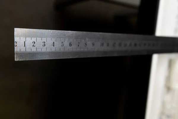 Iron ruler with numbers on black background — Stock Photo, Image