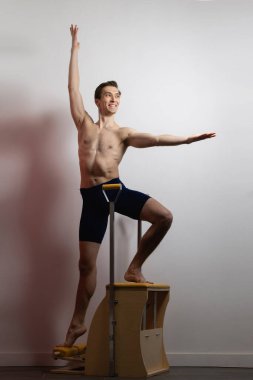 Pilates reformer chair man fitness yoga gym exercise. Correction of musculoskeletal system, beautiful body.