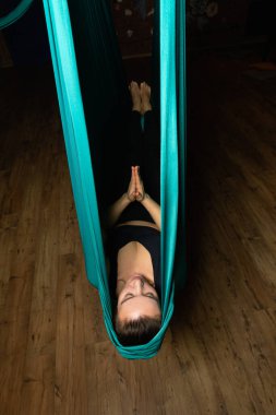 Training on a hammock with a beautiful girl. Fly yoga in the gym. Aero yoga.