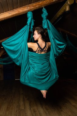 Training on a hammock with a beautiful girl. Fly yoga in the gym. Aero yoga.