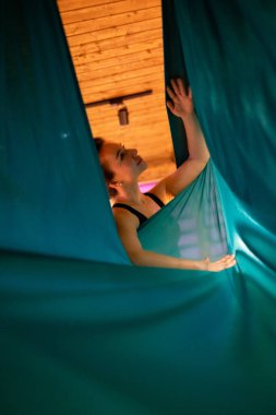 Training on a hammock with a beautiful girl. Fly yoga in the gym. Aero yoga.