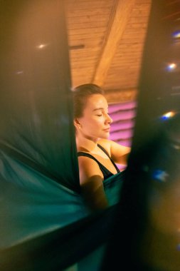 Training on a hammock with a beautiful girl. Fly yoga in the gym. Aero yoga.