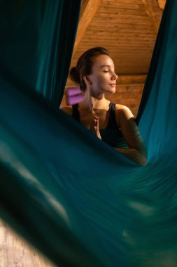 Training on a hammock with a beautiful girl. Fly yoga in the gym. Aero yoga.