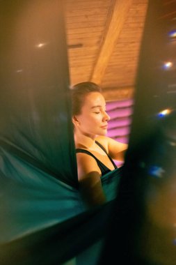 Training on a hammock with a beautiful girl. Fly yoga in the gym. Aero yoga.