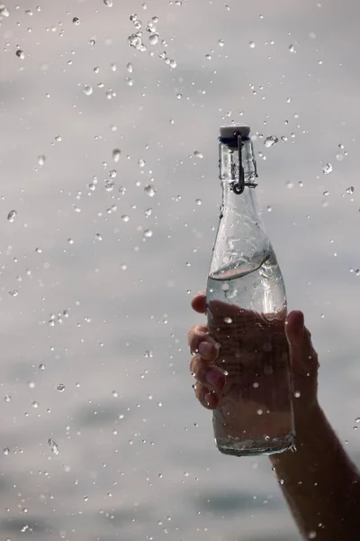 Bottiglia con acqua pura e spruzzi intorno ad essa Immagine Stock